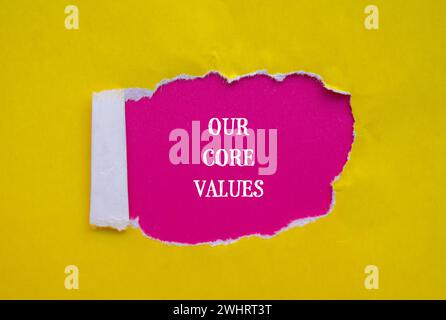 Our core values words written on yellow torn paper with pink background. Conceptual business symbol. Copy space. Stock Photo