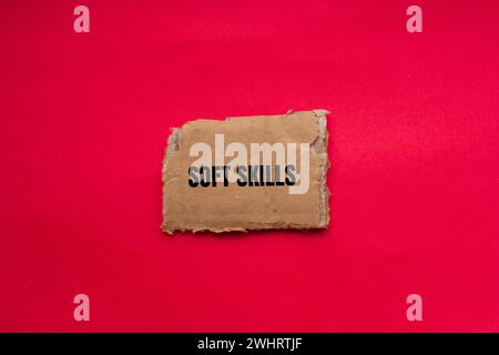 Soft skills word written on torn cardboard paper with red background. Conceptual symbol. Copy space. Stock Photo