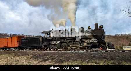 View of a Restored Narrow Gauge Steam Locomotive Blowing Smoke and Steam Stock Photo