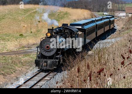 Front and Slightly Above View Approaching Restored Narrow Gauge Passenger Steam Train Blowing Smoke Stock Photo