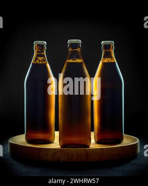 Three cool beer bottles on wooden tray and black background Stock Photo