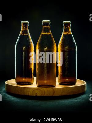 Three cool beer bottles on wooden tray Stock Photo