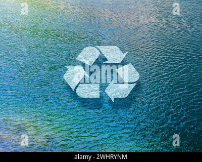 Recycling icon sign floating on the natural blue water surface, lake background. Recycle water, conserving environmental resources, green ecology sust Stock Photo