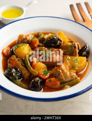 Stewed rabbit with potatoes, green beans, carrots and tomato. Stock Photo