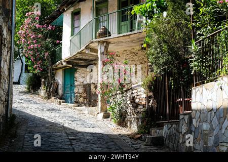 Stoned footpath crossing a traditional village. Stoned houses with wooden doors. Vintage architecture. Stock Photo