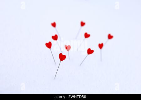 Red hearts on a pins in snow. Greeting card, romantic love, Valentine's day Stock Photo