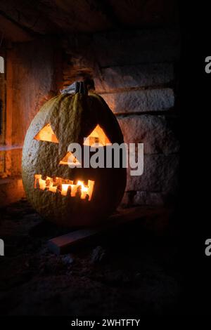 Scary Halloween pumpkin glowing in window at night Stock Photo