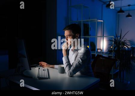 Side view of businessman touching chin thinking business problems in office. Frustrated pensive man working computer analyzing strategy. Stock Photo