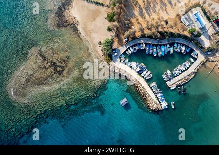 Aerial drone view of fishing harbour and sandy holiday beach for swimming. Stock Photo