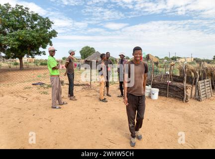 african village ,men having a meeting next to an outdoors kitchen , huts, mud houses and rondavel Stock Photo