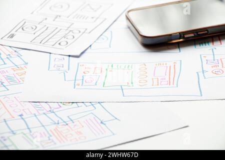 Development and sketches on paper of a custom mobile application on the desktop, graphic design, designer work Stock Photo