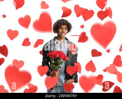 African american young man holding a bunch of roses and standing under falling hearts isolated on white background Stock Photo