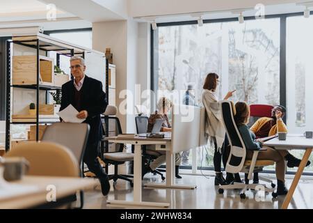 Successful team of diverse colleagues collaborating and discussing business strategy at the office. Stock Photo