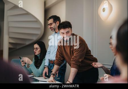 Dynamic image of a collaborative team engaging in a discussion at a modern office environment, with a focus on teamwork and communication. Stock Photo