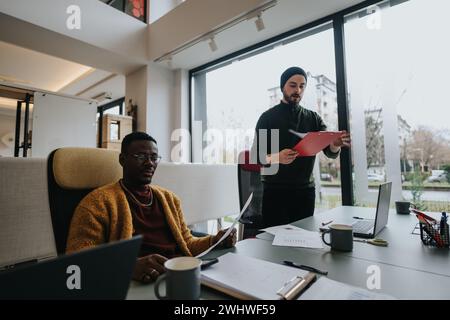 Multiethnic business employees discussing work strategies in a modern office setting. Stock Photo