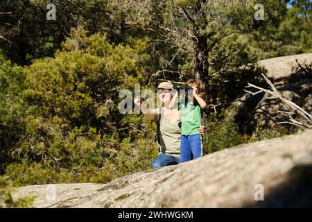 Mother and son in woods with binoculars Stock Photo