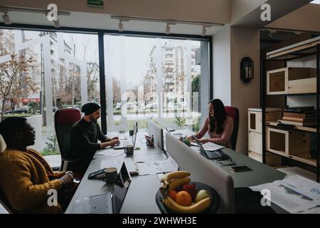 A multiethnic group of professionals working together in a well-lit office environment, featuring a vibrant, collaborative workspace. Stock Photo