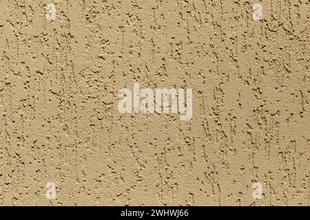 Sand decorative relief . Yellow-brown stucco wall. Background of the wall. Stock Photo