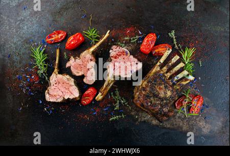 Traditional grilled rack of lamb with paprika and herbs served as top view on a rustic board Stock Photo