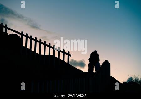 Backlit silhouette of two friends hugging at sunset. Friendship concept. High quality photo Stock Photo