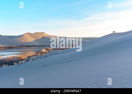 Sand Dunes sunset, People standing on sand dune, Sand dune formations, Desert Oasis, Bruneau Dunes State Park, Owyhee County, Owyhee Desert, Idaho Stock Photo