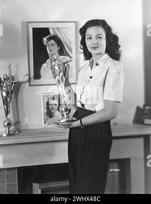 British Film Actress MARGARET LOCKWOOD holding her Daily Mail Film Award as Best Actress of the Year 1947 inside her flat in Roehampton, Southwest London. On the mantelpiece is the trophy she won the previous year in 1946 for Most Outstanding Actress During The War Years Rank Films Publicity Stock Photo