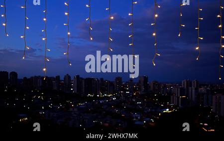 Christmas lights and blurred city in the background Stock Photo