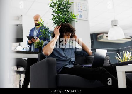 Arab entrepreneur happy about high product sales roi, checking financial report on laptop. Excited start up company executive manager holding head while analyzing investment profit Stock Photo