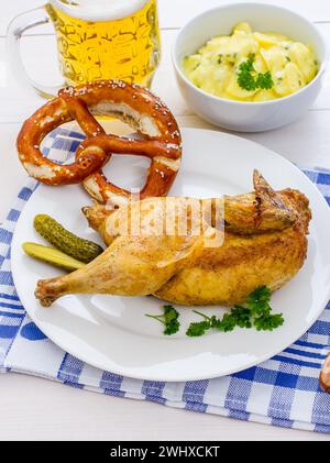 Half roast chicken, beer, pretzel and potato salad Stock Photo