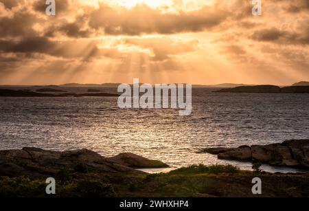 Dramatic sunbeams over sea shore Stock Photo