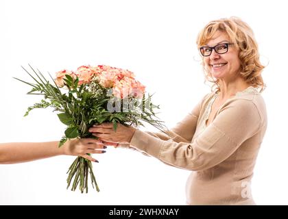 Mature, beautiful blonde woman gets bouquet of flowers, isolated Stock Photo