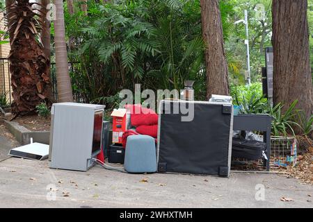 Household goods dumped on an apartment block driveway, kitchen appliances, furniture, personal goods. signs of housing & rental stress in the market Stock Photo