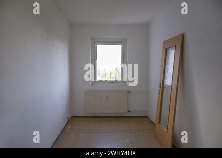 Small room in need of renovation, the door leaning against the wall, concept for affordable living space out of reach in times o Stock Photo