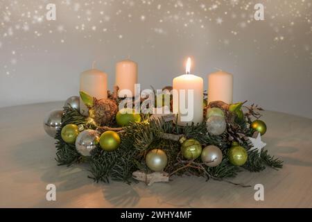 First Advent, wreath with one burning white candle and green Christmas decoration on a table, home decor for the first Sunday, c Stock Photo