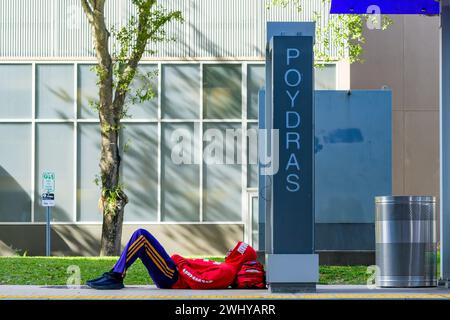 NEW ORLEANS, LA, USA - DECEMBER 31, 2023: Smartly dressed man wearing colorful athletic apparel reclining at the Poydras streetcar stop on Loyola Ave. Stock Photo