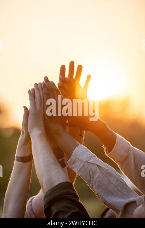 Diverse Group High-Fiving at Sunset Stock Photo