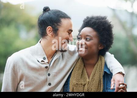 Students, university and multiracial couple of friends on campus with hug and an embrace together outdoor. College, school education and diversity Stock Photo