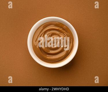 Boiled condensed milk, bowl of melted caramel cream, top view Stock Photo