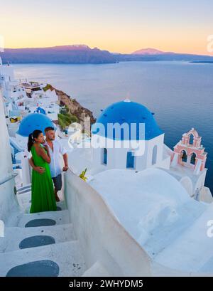 A couple of men and woman on vacation in Greece visited the village of Oia Santorini during sunset Stock Photo