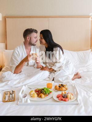 Couple having breakfast in bed, men and women in bedroom having breakfast in the morning Stock Photo