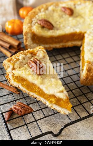 Fall traditional pie pumpkin with crumble and pecan on a gray stone background. Thanksgiving dessert. Stock Photo