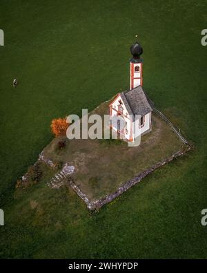 Val Di Funes, Dolomites, Italy - Aerial view of the beautiful St. Johann Church (Chiesetta di San Giovanni in Ranui) at South Tyrol with green grass, Stock Photo