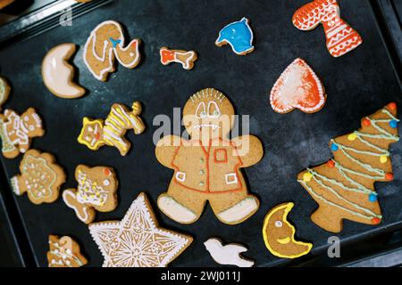 Colorful Christmas cookies with icing lie on a baking sheet on the table Stock Photo