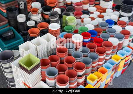 Many different shapes, round, square and color plastic pots for growing plants on the counter in a garden store. Stock Photo