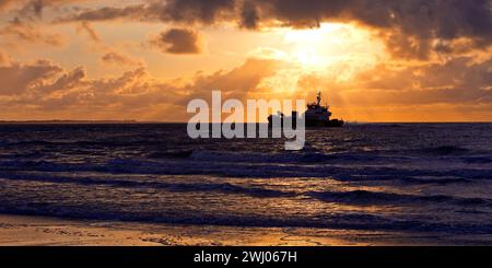 Sea at sunset with the offshore supply ship FARRA CLIONA, North Sea, Norderney, Germany, Europe Stock Photo