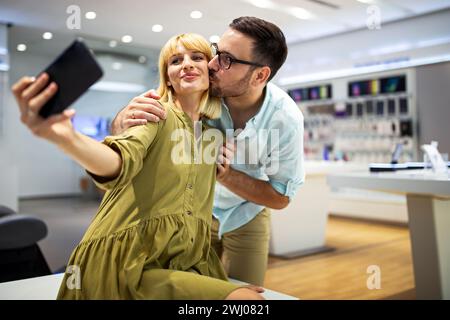 Couple is making selfie using a smart phone. Digital device, artificial intelligence concept. Stock Photo