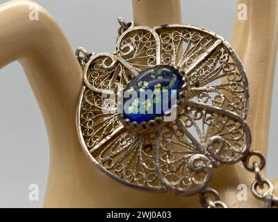 Blue glass brooch on metal vase Stock Photo