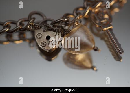 Two heart-shaped keys resting on a delicate bracelet Stock Photo