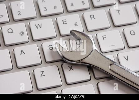Computer maintenance and technical support. Wrench on a computer keyboard. Stock Photo