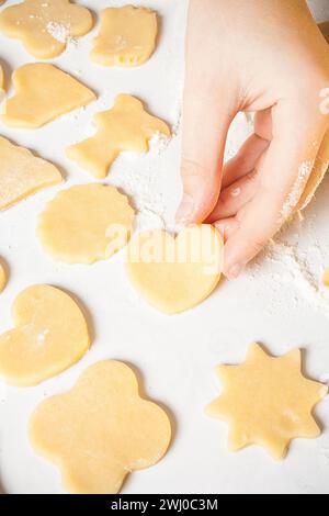 Girl shows heart shape out of dough Stock Photo